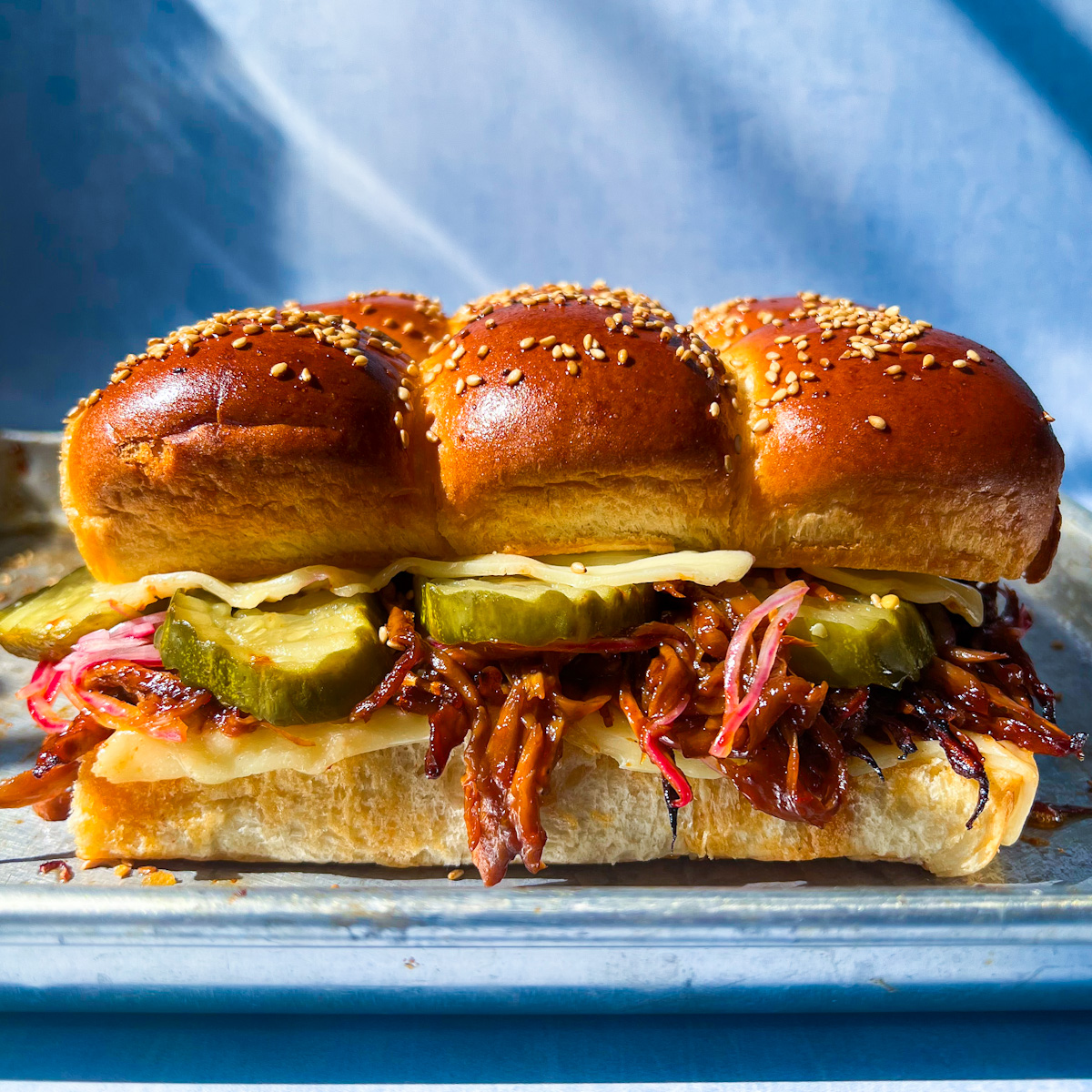 BBQ pulled mushroom sliders made with shredded king oyster mushrooms and melted cheese