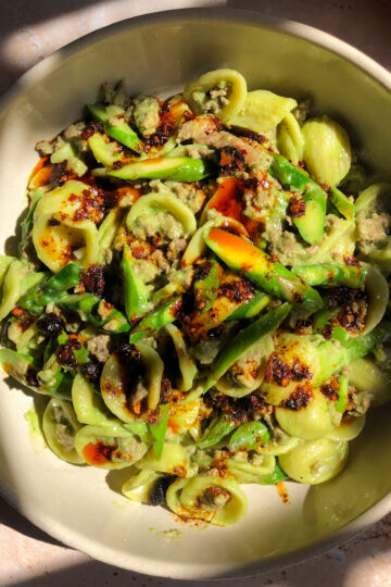 Creamy cilantro lamb pasta with orecchiette and fresh asparagus in a bowl