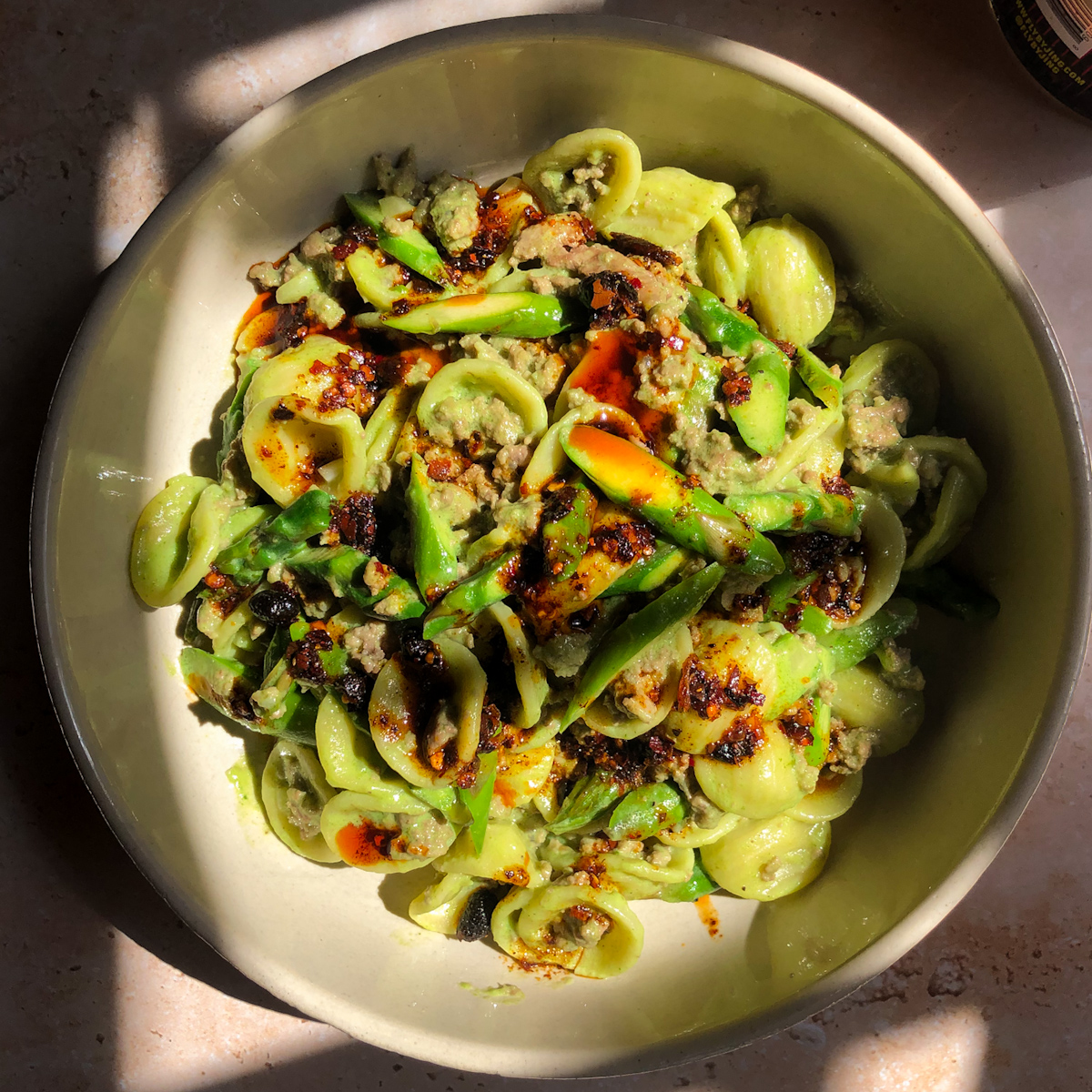 Creamy cilantro lamb pasta with orecchiette and fresh asparagus in a bowl