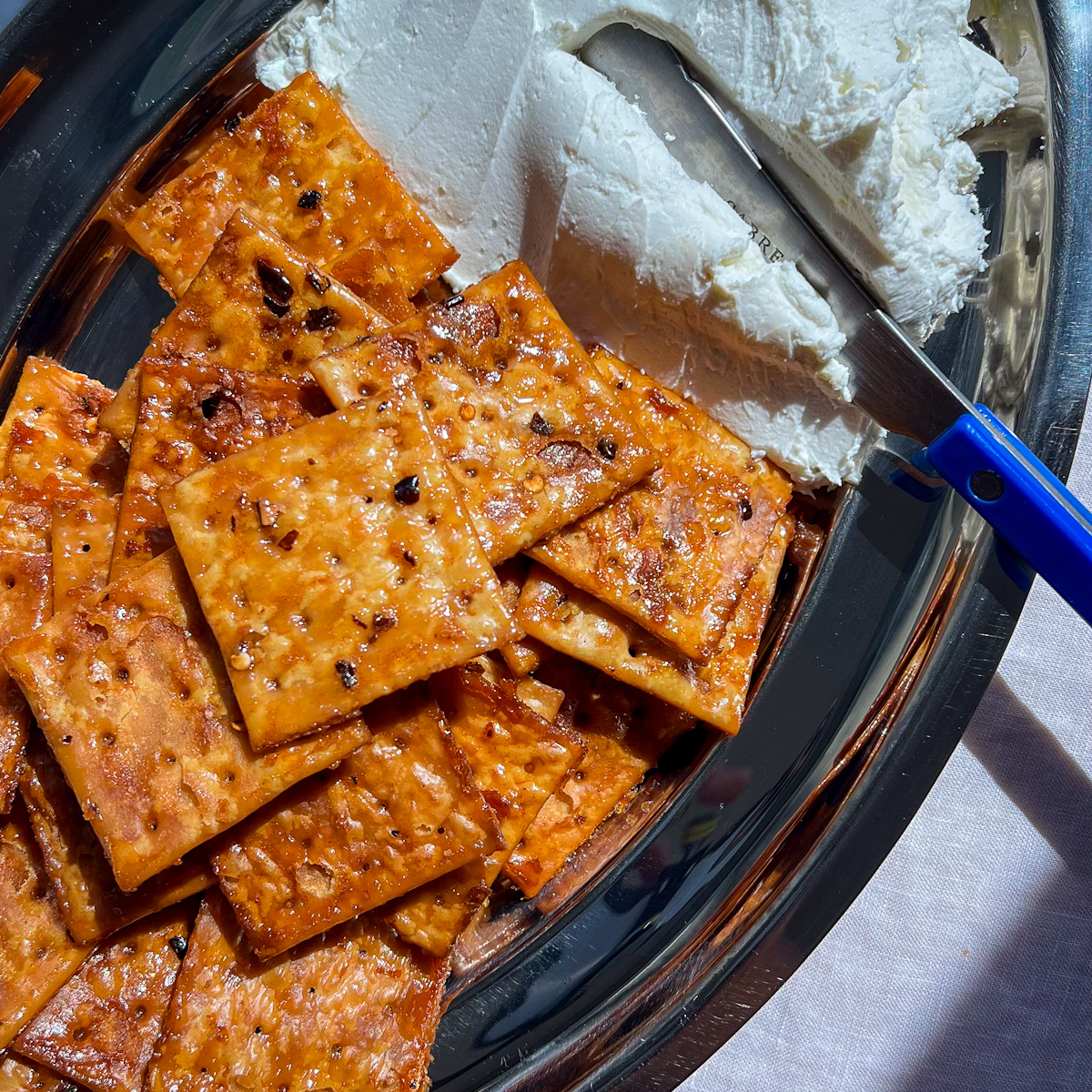 Hot honey saltines and whipped goat cheese on a silver platter