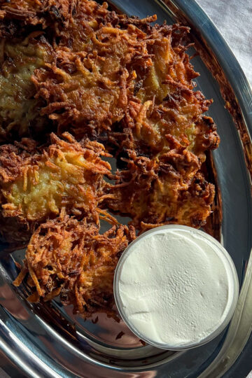 Crispy potato latkes on a silver platter