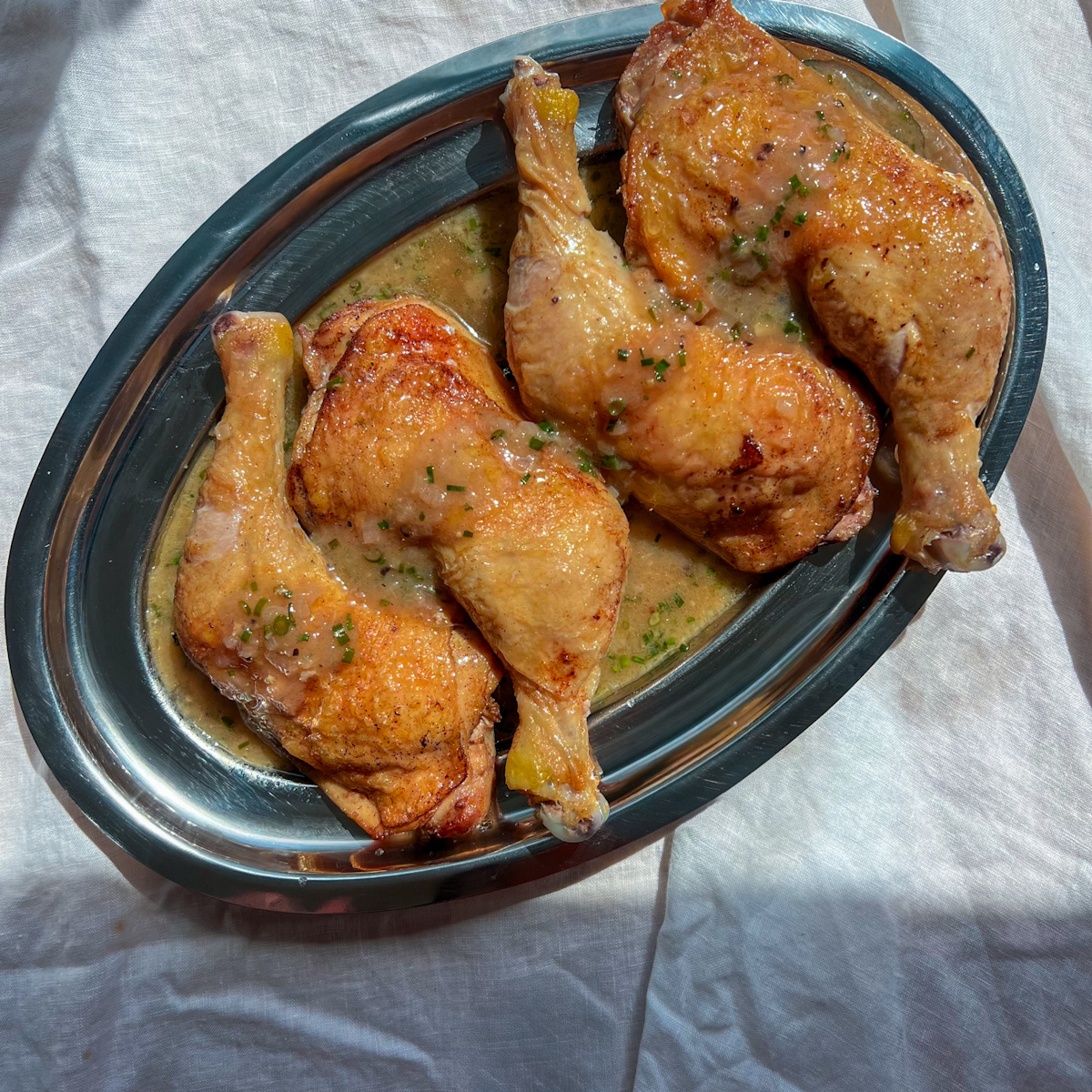 Crispy chicken legs served with a glossy shallot vinegar pan sauce and chives