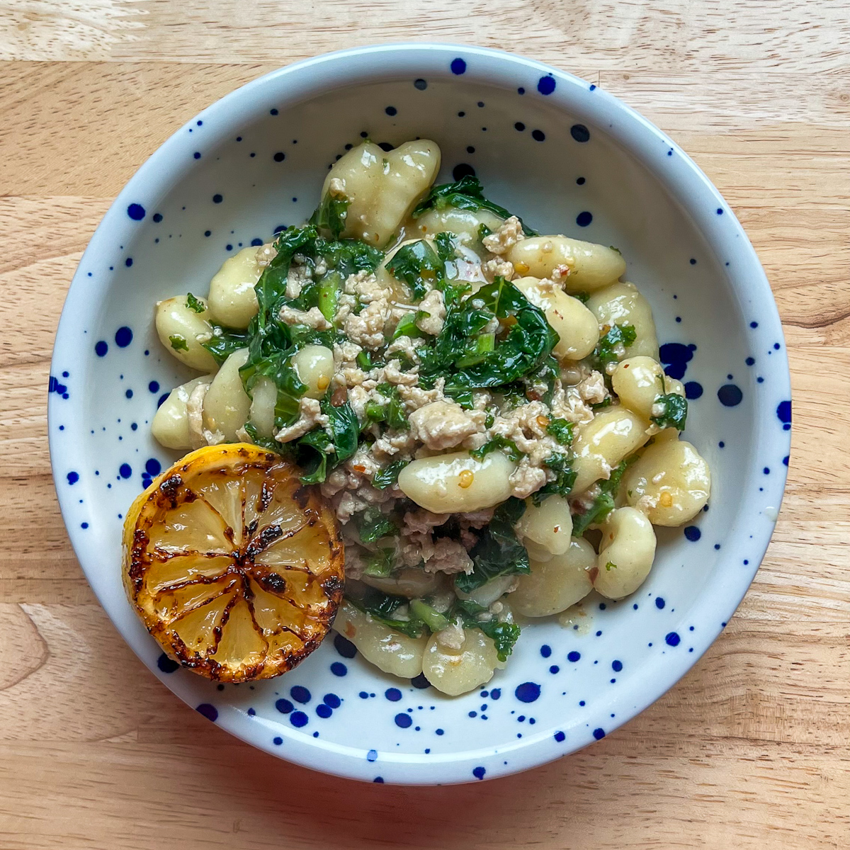 Lemon Chicken Gnocchi in a blue speckled bowl